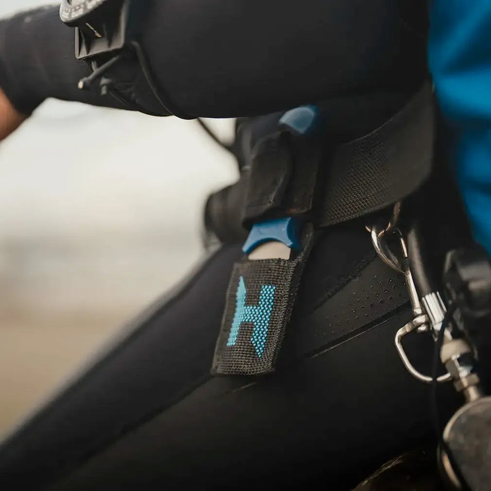 Close-up of a Hlacyon Multitool knife on a harness with a Halcyon logo.