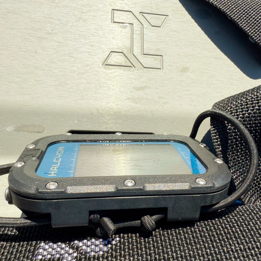 Halcyon Symbios Blue Dive Computer resting on webbing with H logo on background