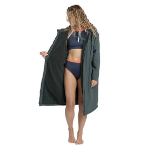 Woman in blue swimsuit wearing Green Fourth Element Tidal Robe, holding the front open