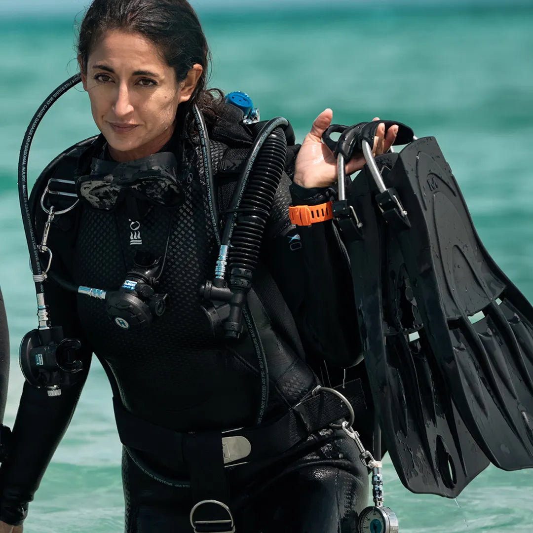 Person in scuba diving gear wearub=n Fourth Element Xenos ARC Wetsuit