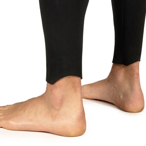 Close-up of feet wearing Fourth Element Xenos ARC 3mm Wetsuit on a white background