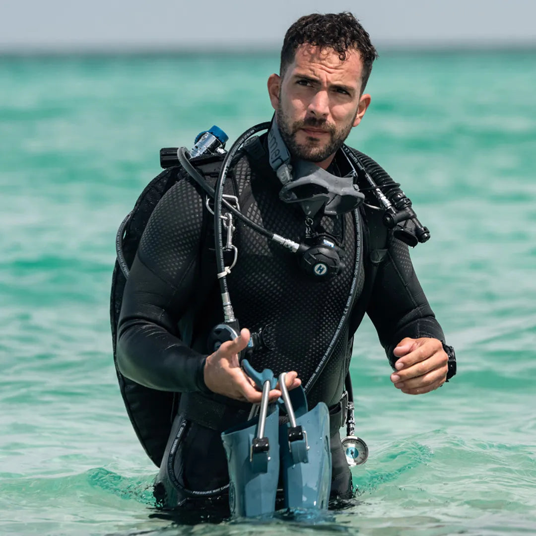 Diver in Fourth Element Xenos ARC 3mm Wetsuit standing in clear water