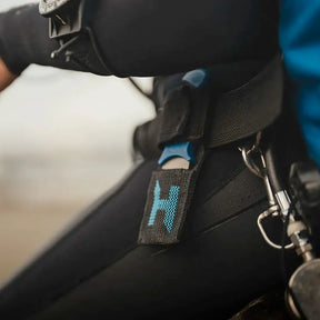 Close-up of a Hlacyon Multitool knife on a harness with a Halcyon logo.